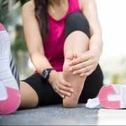 foot stress fracture test, young woman massaging her painful foot while exercising running sport and excercise injury concept