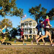 runners in the mississippi gulf coast marathon pass in front of a house